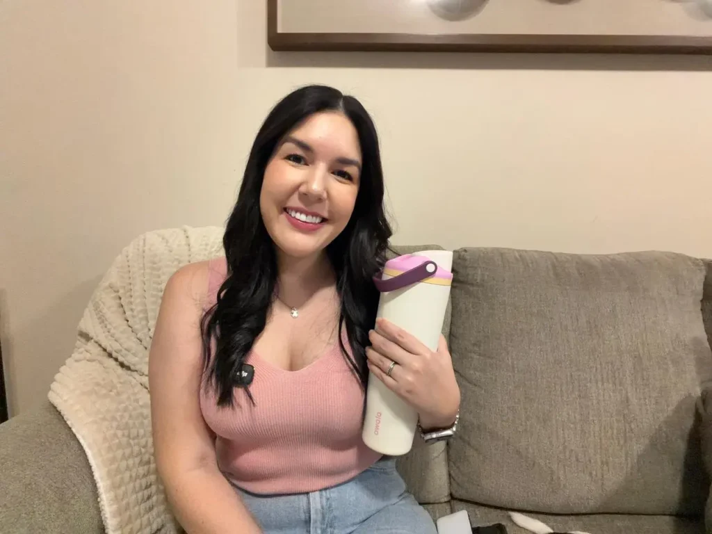 Luci Abarca mostrando su botella de agua Owala FreeSip color Daybreak en la sala de su casa